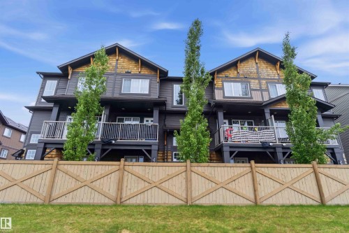 Modern townhouse exterior featuring dark siding, decorative wood shingles, prominent gables, and individual balconies - 36 1005 Graydon Hill Boulevard, Edmonton, AB 