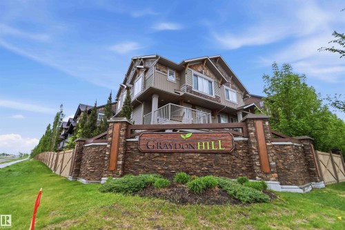Stone and wood-clad entrance monument with integrated signage - 36 1005 Graydon Hill Boulevard, Edmonton, AB 