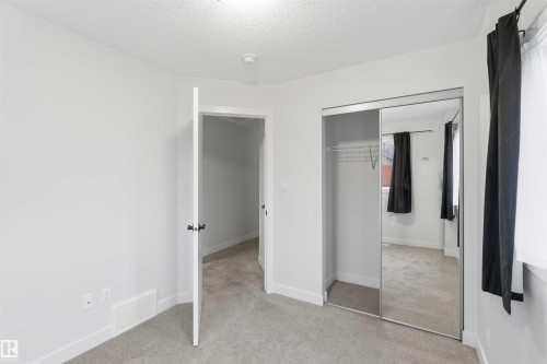 Bright interior room featuring light gray carpet, white painted walls, and a ceiling-mounted light fixture - 36 1005 Graydon Hill Boulevard, Edmonton, AB 