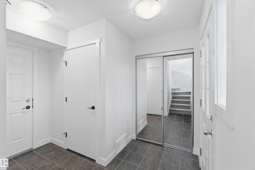 Entryway with dark tile flooring, white walls, and a recessed ceiling light fixture - 36 1005 Graydon Hill Boulevard, Edmonton, AB 