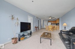 Open-concept living area featuring light blue walls and neutral carpet flooring - 