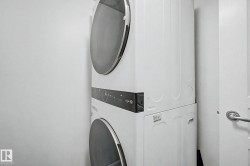 Stackable white washer and dryer unit with front-loading doors and digital controls - 