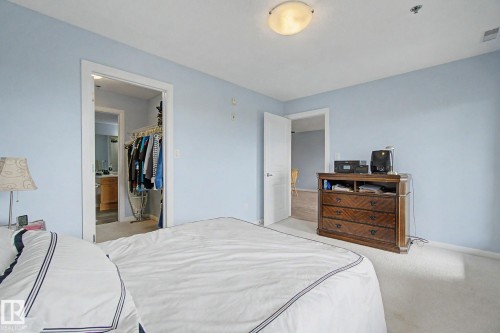 Carpeted room with light blue walls and a semi-flush mount ceiling light - 303 530 Hooke Road, Edmonton, AB - Indoor Photo Showing Bedroom