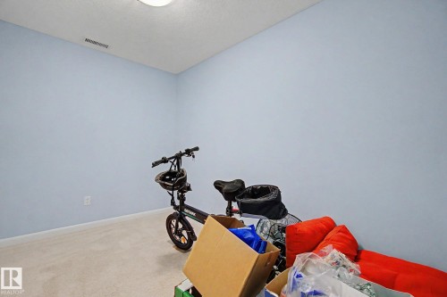 Room featuring light blue walls, neutral carpet, and a ceiling-mounted light fixture - 303 530 Hooke Road, Edmonton, AB - Indoor Photo Showing Gym Room