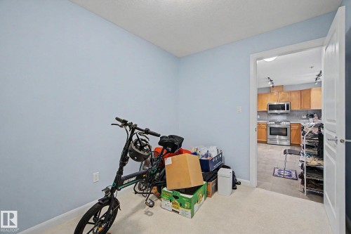 Carpeted room with light blue wall finish - 303 530 Hooke Road, Edmonton, AB - Indoor Photo Showing Other Room