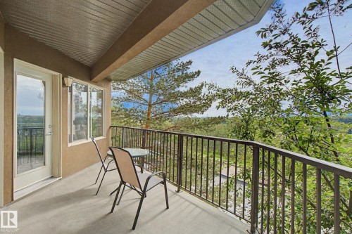 Exterior balcony featuring a concrete floor, dark metal railing, and a durable soffit ceiling - 303 530 Hooke Road, Edmonton, AB - Outdoor With Exterior