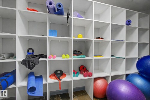 Built-in cubby storage system featuring white shelving and a multi-grid design - 303 530 Hooke Road, Edmonton, AB - Indoor With Storage