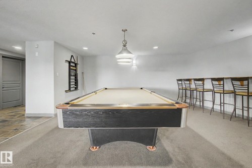 Recreational room featuring a billiards table, built-in bar seating, recessed lighting, and a pendant light fixture - 303 530 Hooke Road, Edmonton, AB - Indoor Photo Showing Other Room