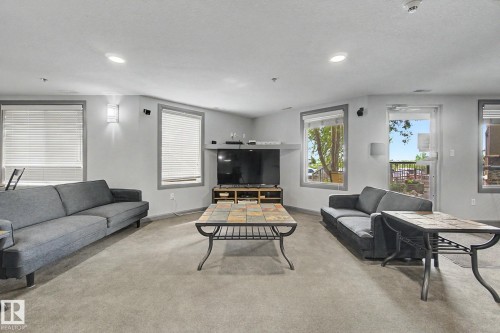 Spacious room featuring light gray walls, wall-mounted lighting, recessed ceiling lights, and multiple windows with blinds - 303 530 Hooke Road, Edmonton, AB - Indoor Photo Showing Living Room