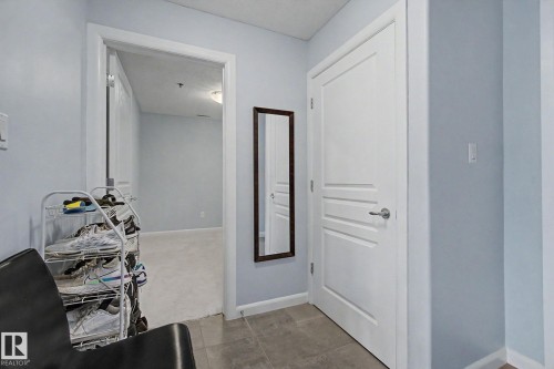 Entryway featuring gray tile flooring and light blue wall paint - 303 530 Hooke Road, Edmonton, AB - Indoor Photo Showing Other Room