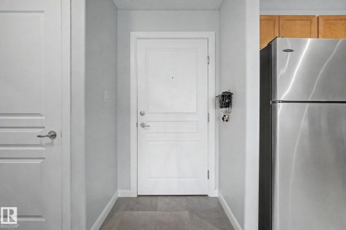 White paneled interior door with brushed nickel hardware - 303 530 Hooke Road, Edmonton, AB - Indoor Photo Showing Other Room