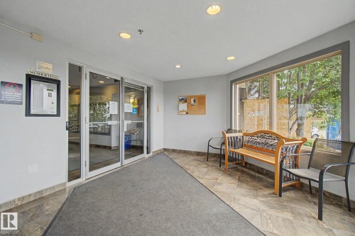 Entry foyer featuring automatic glass doors, recessed lighting, large windows, and tile flooring - 303 530 Hooke Road, Edmonton, AB - Indoor Photo Showing Other Room