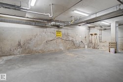 Concrete floor and unfinished concrete walls with exposed ductwork and fluorescent lighting - 