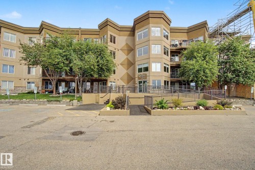 Multi-story residential building featuring a stone facade base and a light-colored exterior finish - 303 530 Hooke Road, Edmonton, AB - Outdoor With Facade