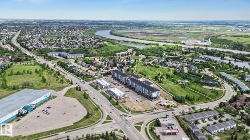 Aerial perspective showcasing a residential and commercial area with a prominent river system - 303 530 Hooke Road, Edmonton, AB - Outdoor With View