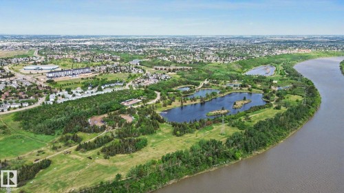 Expansive natural landscape featuring a winding river, dense tree lines, multiple lakes, and surrounding urban development - 303 530 Hooke Road, Edmonton, AB - Outdoor With View