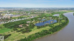 Expansive natural landscape featuring a winding river, dense tree lines, multiple lakes, and surrounding urban development - 