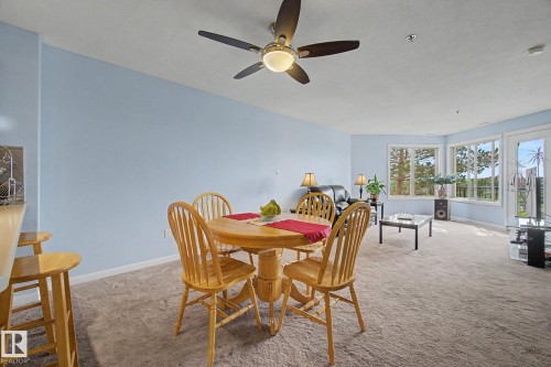 Open-concept living area with light blue walls and neutral carpeting - 303 530 Hooke Road, Edmonton, AB - Indoor Photo Showing Dining Room