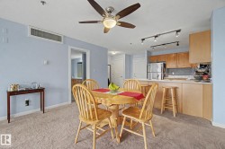 Dining area featuring a ceiling fan with integrated lighting, soft blue walls, and light-toned carpet flooring - 