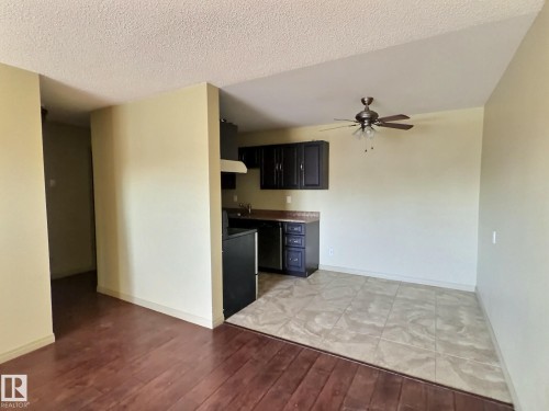 Open-concept living area featuring wood-finish flooring transitioning to tile - 306 9730 156 Street, Edmonton, AB 