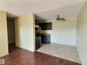 Open-concept living area featuring wood-finish flooring transitioning to tile - 306 9730 156 Street, Edmonton, AB 
