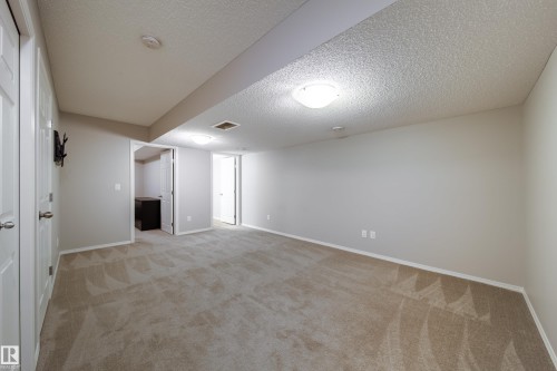Spacious carpeted room with neutral wall tones - 3038 Checknita Way Sw, Edmonton, AB 