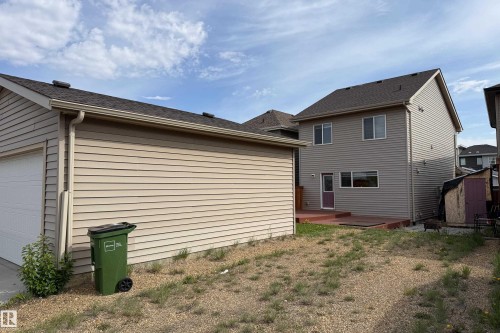Two-story home with light-colored siding and an attached deck - 3038 Checknita Way Sw, Edmonton, AB 