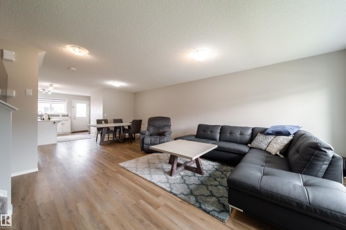Open-concept living space featuring wood-finish flooring, recessed lighting, and neutral wall tones - 3038 Checknita Way Sw, Edmonton, AB 