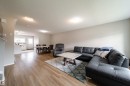 Open-concept living space featuring wood-finish flooring, recessed lighting, and neutral wall tones - 3038 Checknita Way Sw, Edmonton, AB 