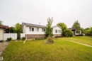 Two-story residence featuring white siding and a stone facade - 8512 142A Avenue, Edmonton, AB 