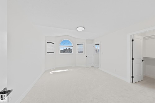 Bright room featuring light-colored carpeting, a ceiling-mounted light fixture, and white walls - 6144 166 Avenue, Edmonton, AB 