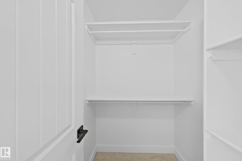 White walk-in closet featuring built-in shelving and hanging rods - 6144 166 Avenue, Edmonton, AB 