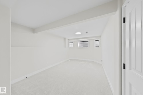 Spacious room featuring light-toned carpeting and neutral wall finishes - 6144 166 Avenue, Edmonton, AB 