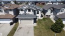 Light-colored siding exterior with contrasting roof, arched window accents, and a two-car garage - 6144 166 Avenue, Edmonton, AB 