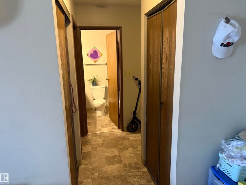 Hallway featuring wood-finish bi-fold closet doors and neutral-toned flooring - 304 10604 110 Avenue, Edmonton, AB 