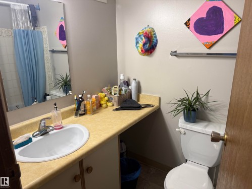 Bathroom featuring a single vanity with an integrated sink, laminate countertop, and chrome faucet - 304 10604 110 Avenue, Edmonton, AB 