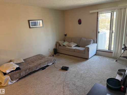 Carpeted room with a sliding glass door and vertical blinds - 304 10604 110 Avenue, Edmonton, AB 