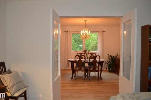 Dining space with light wood-finish flooring and a central window - 68 Marlboro Road, Edmonton, AB 