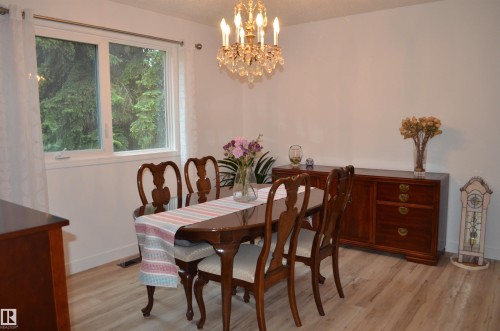 Dining area featuring light wood-finish flooring, white walls, and a crystal chandelier - 68 Marlboro Road, Edmonton, AB 