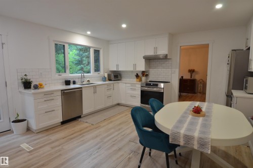 Modern kitchen featuring white cabinetry, light countertops, and a subway tile backsplash - 68 Marlboro Road, Edmonton, AB 