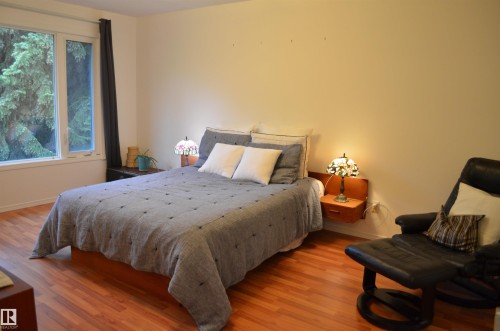 Spacious room featuring large windows, wood-finish flooring, light-toned walls, and recessed lighting - 68 Marlboro Road, Edmonton, AB 