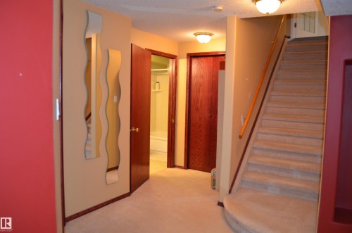 Carpeted staircase with a wood handrail, presenting access to another level - 68 Marlboro Road, Edmonton, AB 
