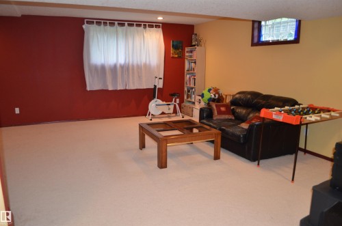 Spacious recreation area featuring light-toned carpeting and exposed ceiling beams - 68 Marlboro Road, Edmonton, AB 