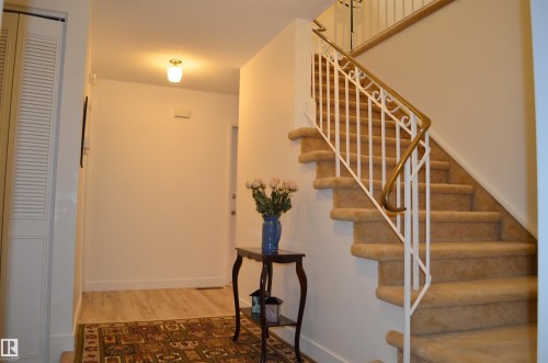 Carpeted staircase featuring a decorative white and brass railing - 68 Marlboro Road, Edmonton, AB 