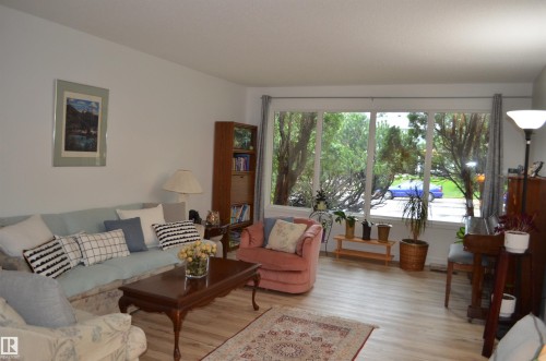 Bright living space featuring light wood-finish flooring and expansive windows - 68 Marlboro Road, Edmonton, AB 