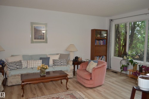 Living area featuring light wood-finish flooring, white walls, and a large window - 68 Marlboro Road, Edmonton, AB 