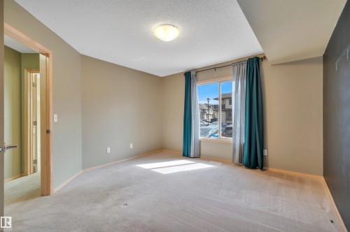 Carpeted interior space featuring a window with natural light, light-toned walls, and a flush mount ceiling light - 40 604 62 Street, Edmonton, AB 