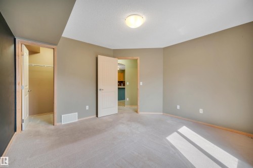 Carpeted room with neutral-toned walls, featuring a ceiling-mounted light fixture - 40 604 62 Street, Edmonton, AB 