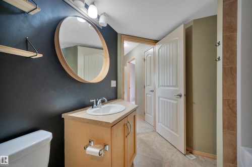 Bathroom vanity with a wood-finish cabinet, integrated sink, and chrome faucet - 40 604 62 Street, Edmonton, AB 
