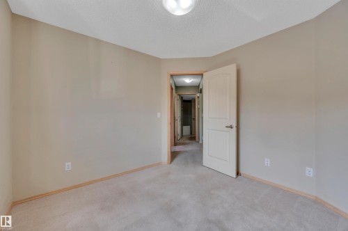 Neutral tone walls with light-colored carpeting, a white paneled door, and a flush mount ceiling light - 40 604 62 Street, Edmonton, AB 